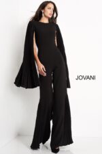 Model wearing Jovani 00756 black jumpsuit with pleated cape sleeves, alternate front view.