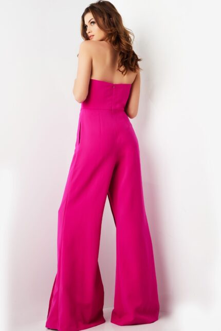 Model wearing Jovani 03828 fuchsia strapless jumpsuit with wide-leg pants, back view.