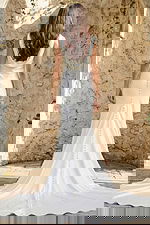 Back view of a fitted satin gown with draped cowl back, button detailing, and flowing train.