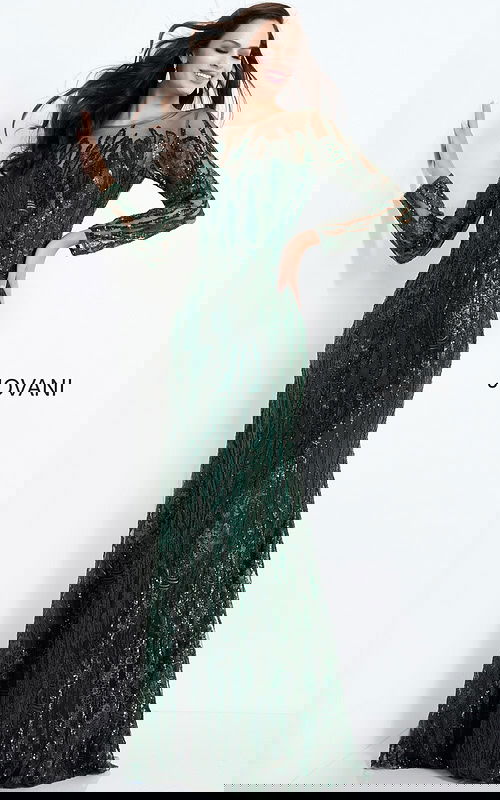 Model wearing Jovani 03936 emerald gown with long sleeves and intricate beading.