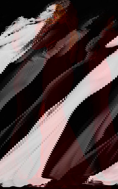 back view of model in Jovani 04501 blush gown featuring high slit