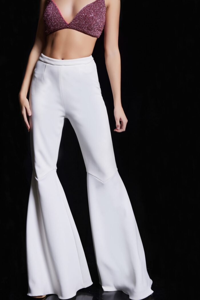 Front view of model in Jovani 05308 ensemble with white flared pants and vibrant beaded top.