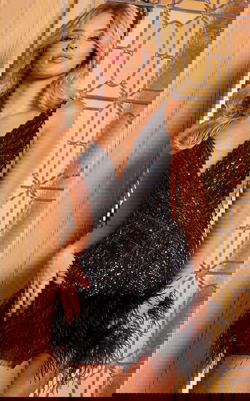 Model wearing Jovani 05535 black mini dress with deep V-neck and feather hem.