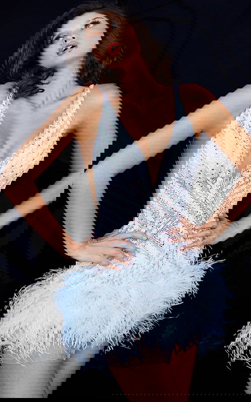 Model wearing Jovani 05535 white dress with V-neckline and feathered hem.