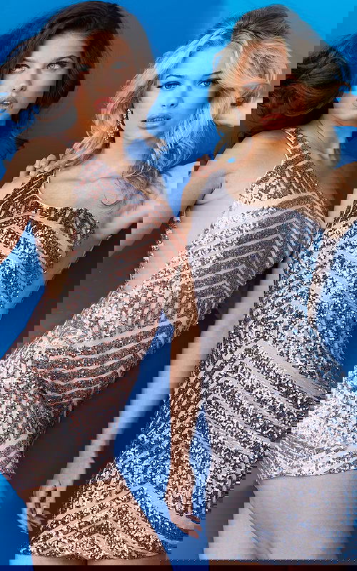 Two models wearing Jovani 06016 sequin short dresses with one-shoulder neckline.