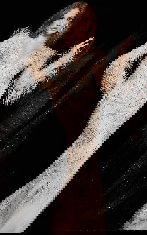 Model wearing Jovani 06305 nude gown with feathered long sleeves and embellishments, front view.