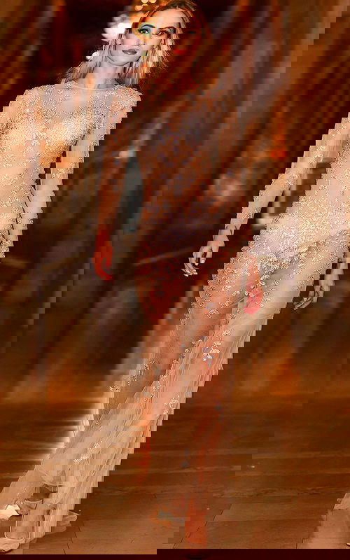 Model wearing Jovani 06546 nude dress with floral embroidery, front view.