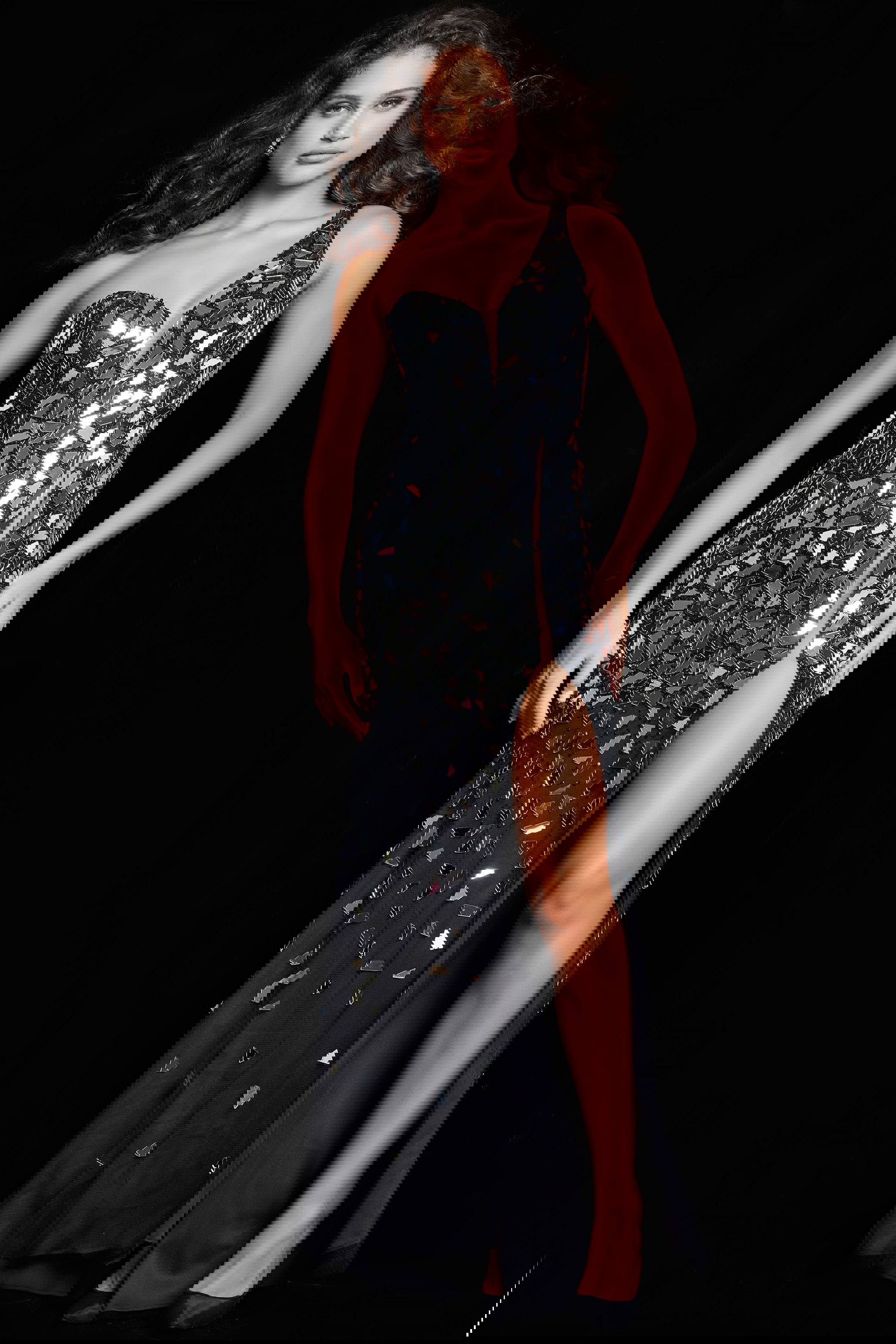 06561_BLACKSILVER.jpg Model wearing Jovani 06561 front view of black gown with reflective embellishments and high slit