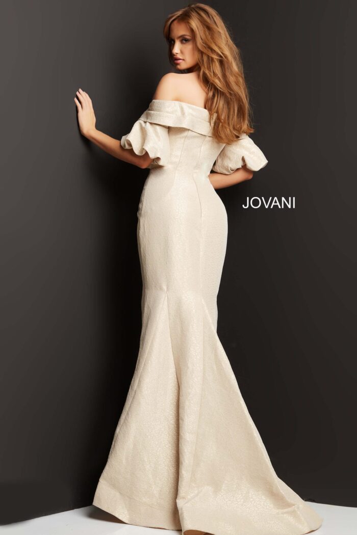 Model in Jovani 06831 beige dress, back view, highlighting elegant mermaid silhouette.