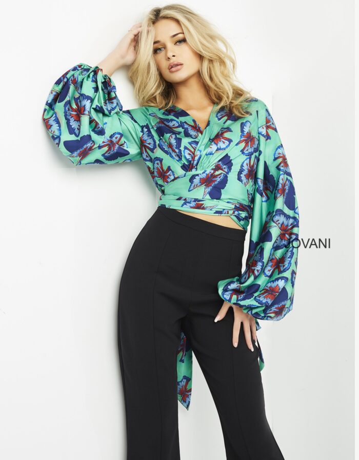 Model wearing Jovani 06844 vibrant print ensemble with crop top and long sleeves.