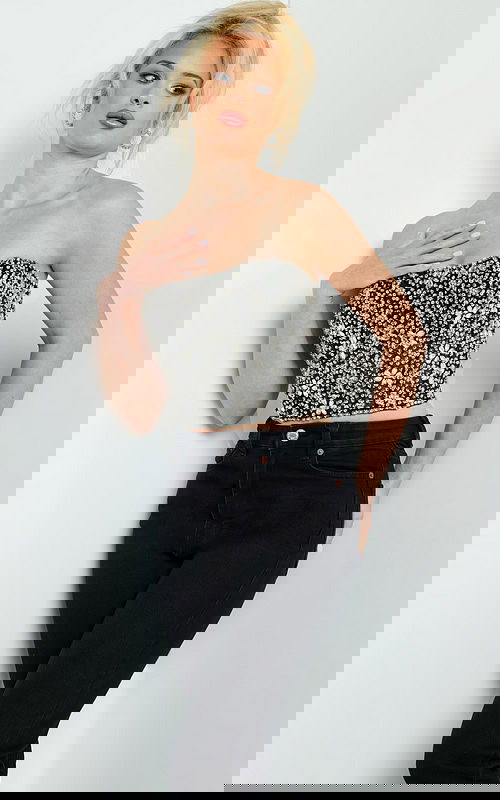 Model wearing Jovani 06854 black crop top with silver embellishments, front view.