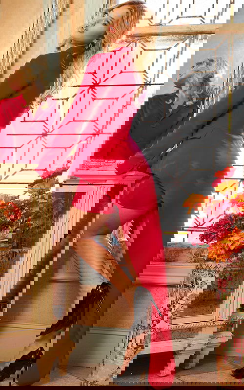 Model wearing Jovani 06876 red high-low blazer dress with train, back view.