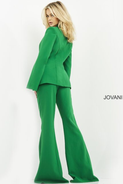 Model wearing Jovani 06922 emerald green jumpsuit with cape sleeves, back view.