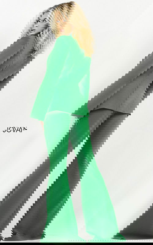 Model wearing Jovani 06922 emerald green jumpsuit with cape sleeves, back view.
