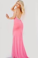 Model wearing Jovani 07297 in hot pink, back view showing low back with embellishments.