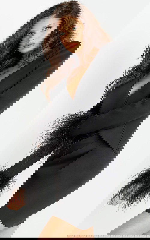 Model wearing Jovani 07916 black knee-length dress, front view with feathered cuffs.