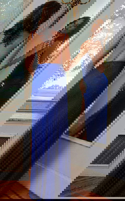 Back view of model wearing Jovani 08531 blue fitted gown with low back and high slit.