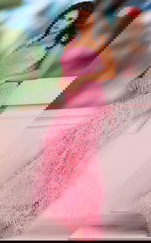 Model wearing Jovani 08200 pink gown with sequin detailing and feathered accents, side view.