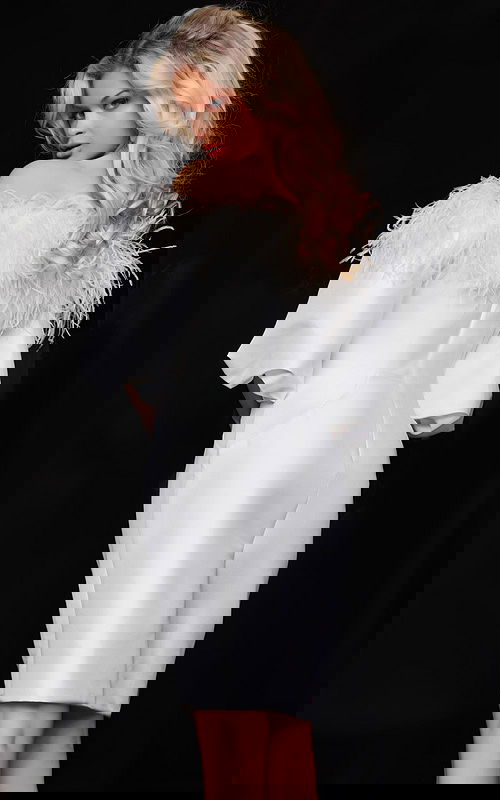 Model wearing Jovani 08211 back view showing off-the-shoulder feather detail and fitted back design.