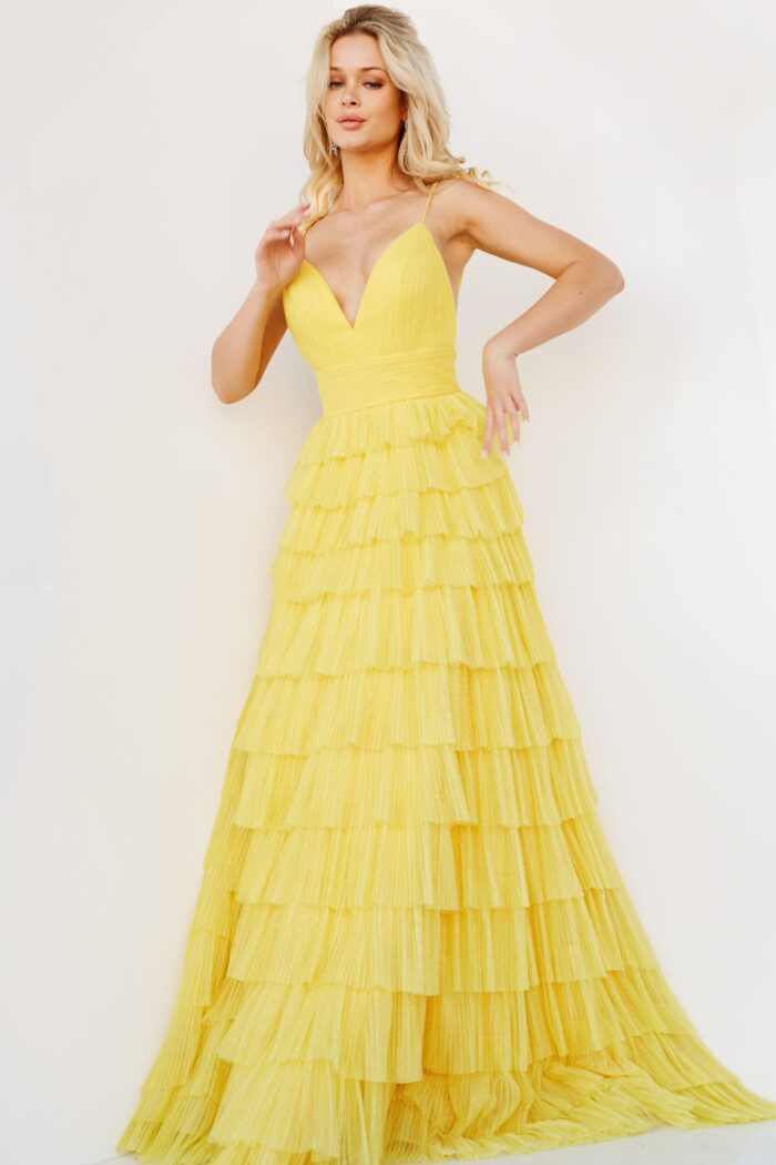 Model wearing Jovani 08480 yellow gown, showcasing tiered ruffle design.