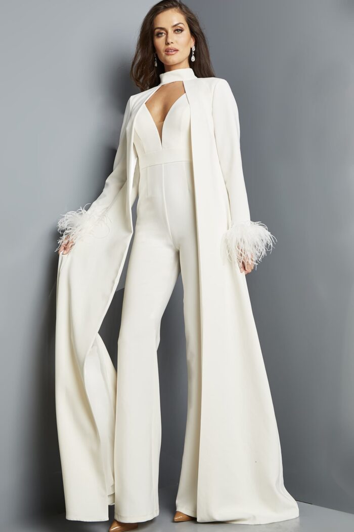 Model wearing Jovani 09479 ivory jumpsuit with coat and feathered cuffs from the front