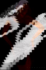 Model wearing Jovani 09483 in ivory with intricate beadwork and feather detail.