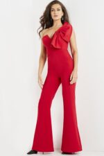 Model wearing Jovani 09525 red jumpsuit, front view highlighting one-shoulder bow.