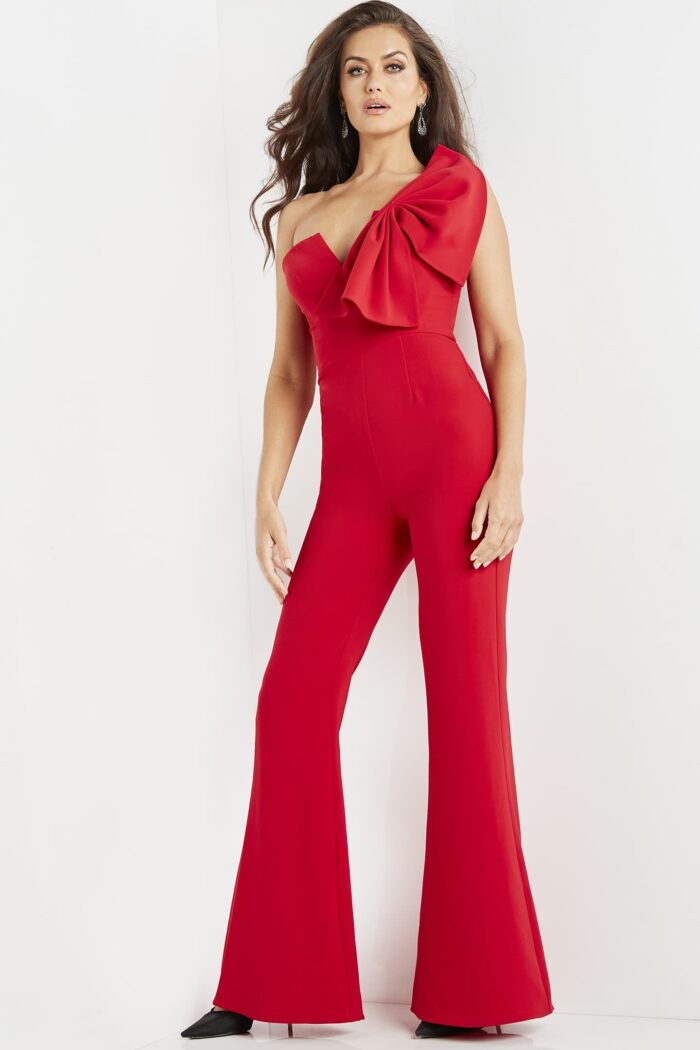Model wearing Jovani 09525 red jumpsuit, front view highlighting one-shoulder bow.