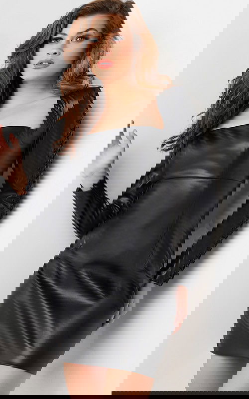 Model wearing Jovani 09585 black mini dress with square neckline and long sleeves, front view.