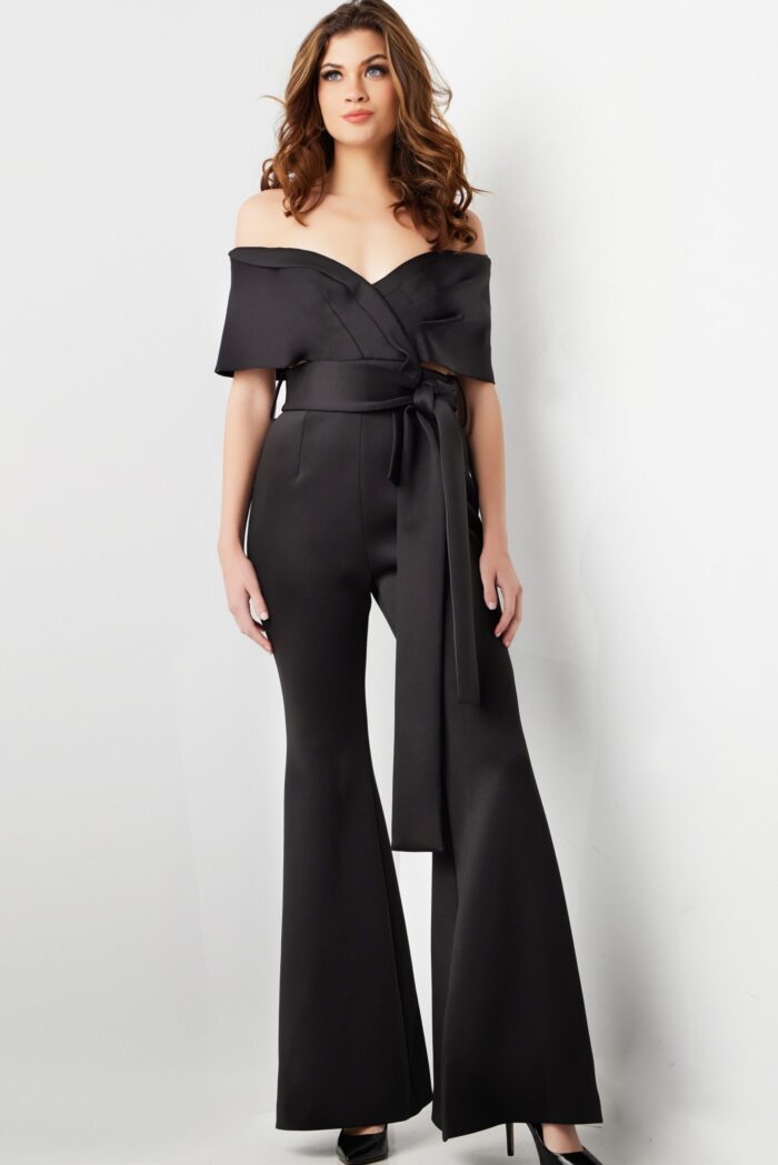 Model wearing Jovani 09726 black off-the-shoulder jumpsuit, another front view
