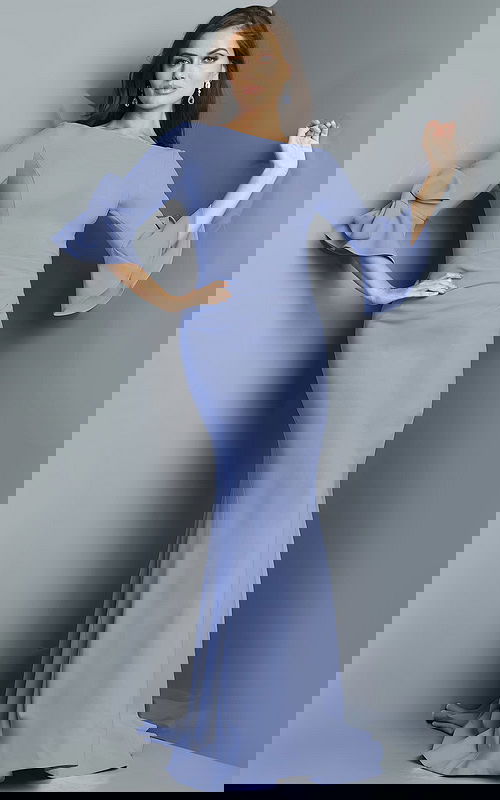 Model wearing 09776 gown with ruffled long sleeves and bateau neckline in periwinkle blue.