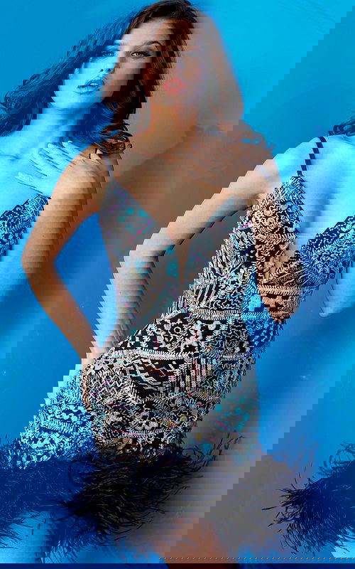 Model wearing Jovani 09817 multi-color dress with V-neckline and feather hem, front view.