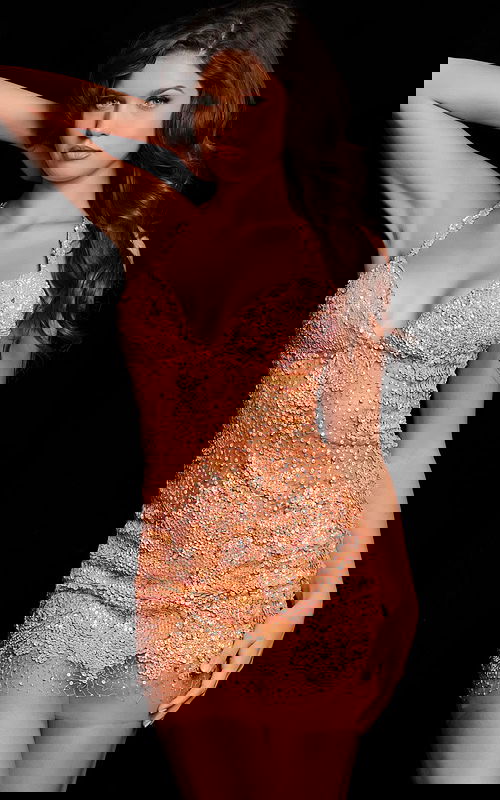 Model wearing Jovani 14338 in neon orange, front view, showing sequined sheath dress with halter neckline.