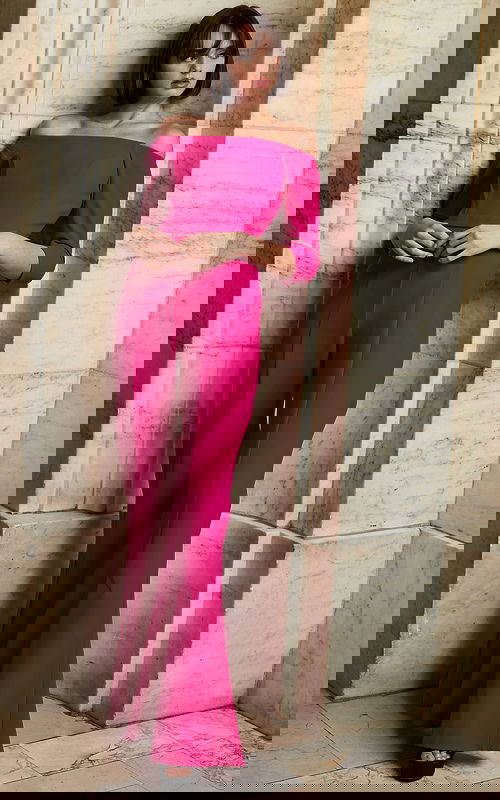 Model wearing Jovani 1867 fuchsia jumpsuit with off-the-shoulder neckline