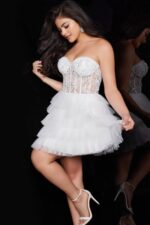 Model posing in Jovani 22227 offwhite mini dress, showcasing the decorative bodice and playful tulle skirt from the front.