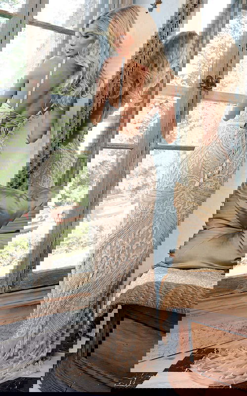 Back view of model in Jovani 22286 nude gown, showcasing lace-up design and detailed beadwork.