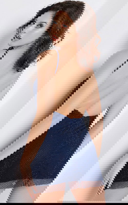 Model showing back of Jovani 22295 navy dress with open back design.