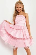 Model twirling in Jovani K22326 pink dress with layered design and feathers.