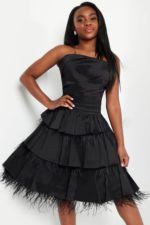 Model in Jovani K22326 black dress featuring an elegant tiered structure.