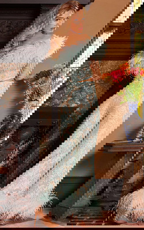 Model wearing Jovani 22350 showcasing the back view with lace details and feathered accents.