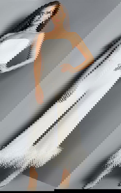 Model wearing Jovani 22590 ivory strapless jumpsuit with feathered hem from the front.