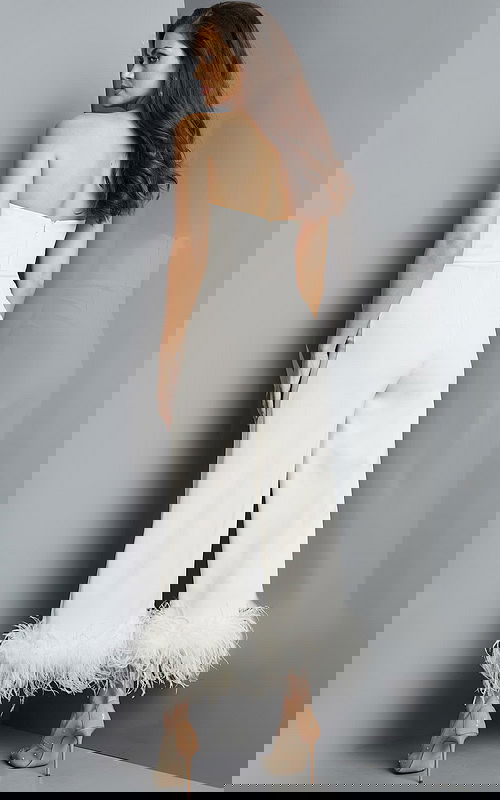 Back view of model wearing Jovani 22590 ivory strapless jumpsuit with feathered hem.