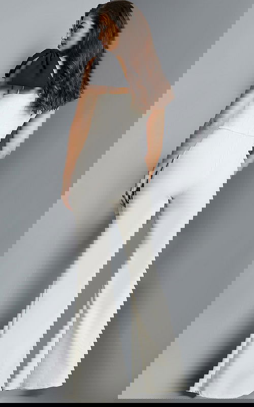 Model wearing Jovani 22589 ivory jumpsuit, back view showcasing the shoulder bow.