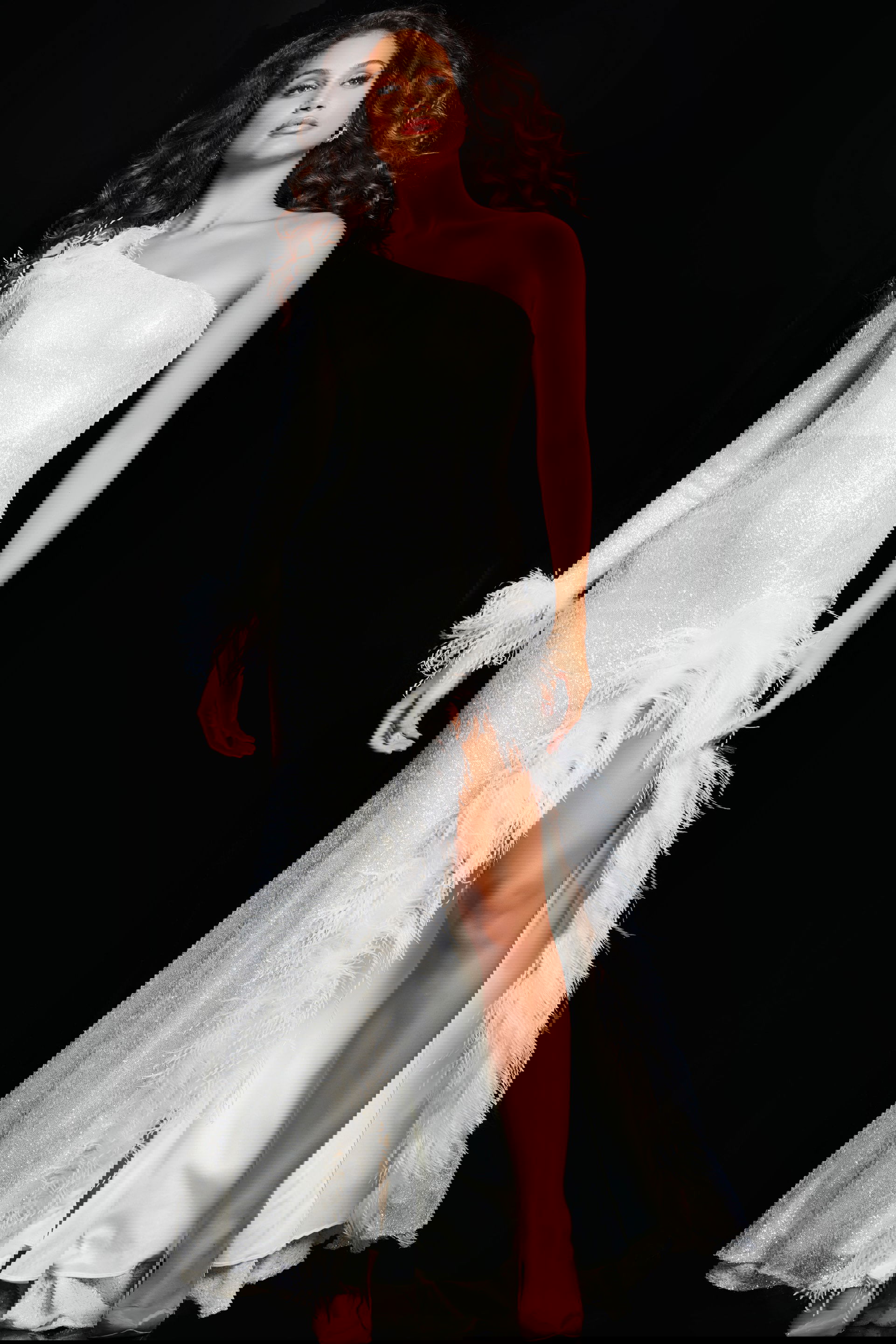 22895_CREAM_15-2.jpg Model wearing Jovani 22895 beige dress with feather detail and high slit.