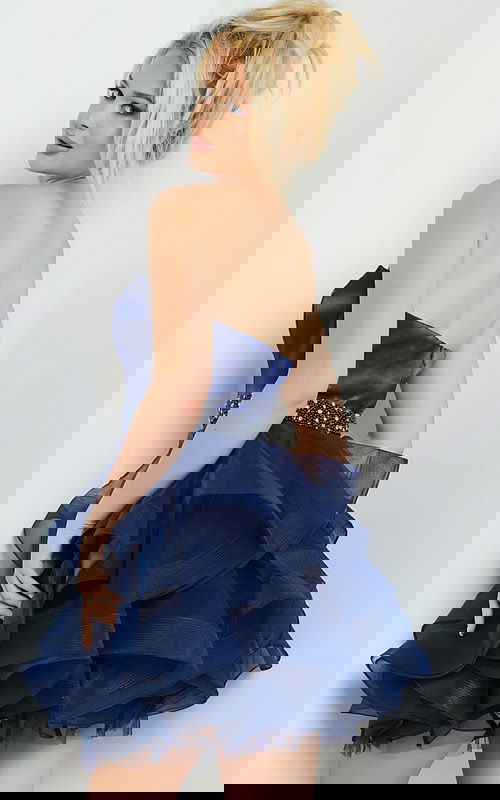 Model showing the back view of the Jovani 22901 navy strapless dress with tulle skirt.