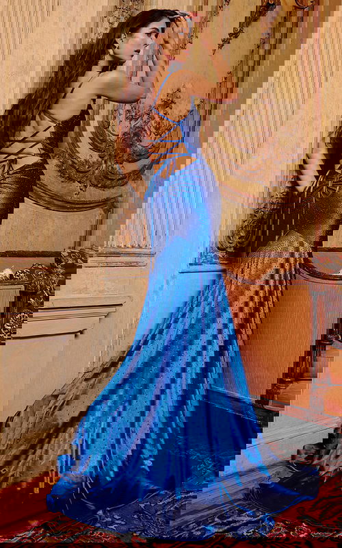 Model in Jovani 23010 blue gown with intricate back design.