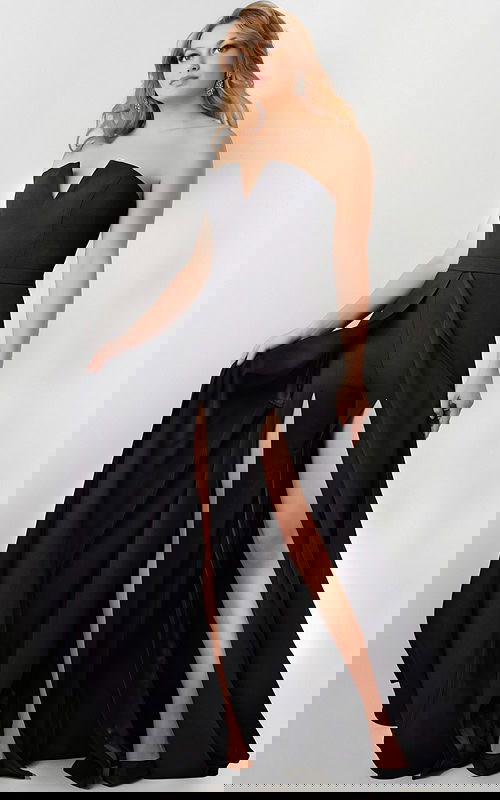 Model wearing Jovani 23150 black gown with sweetheart neckline and high slit.