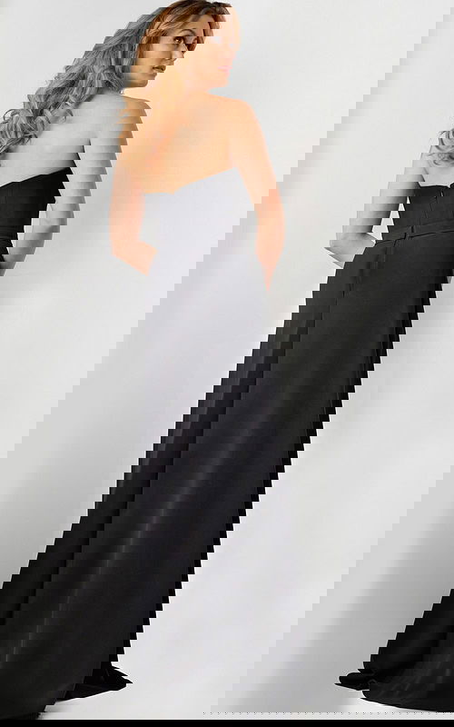 Model wearing Jovani 23150 black gown showing back view with full-length skirt.