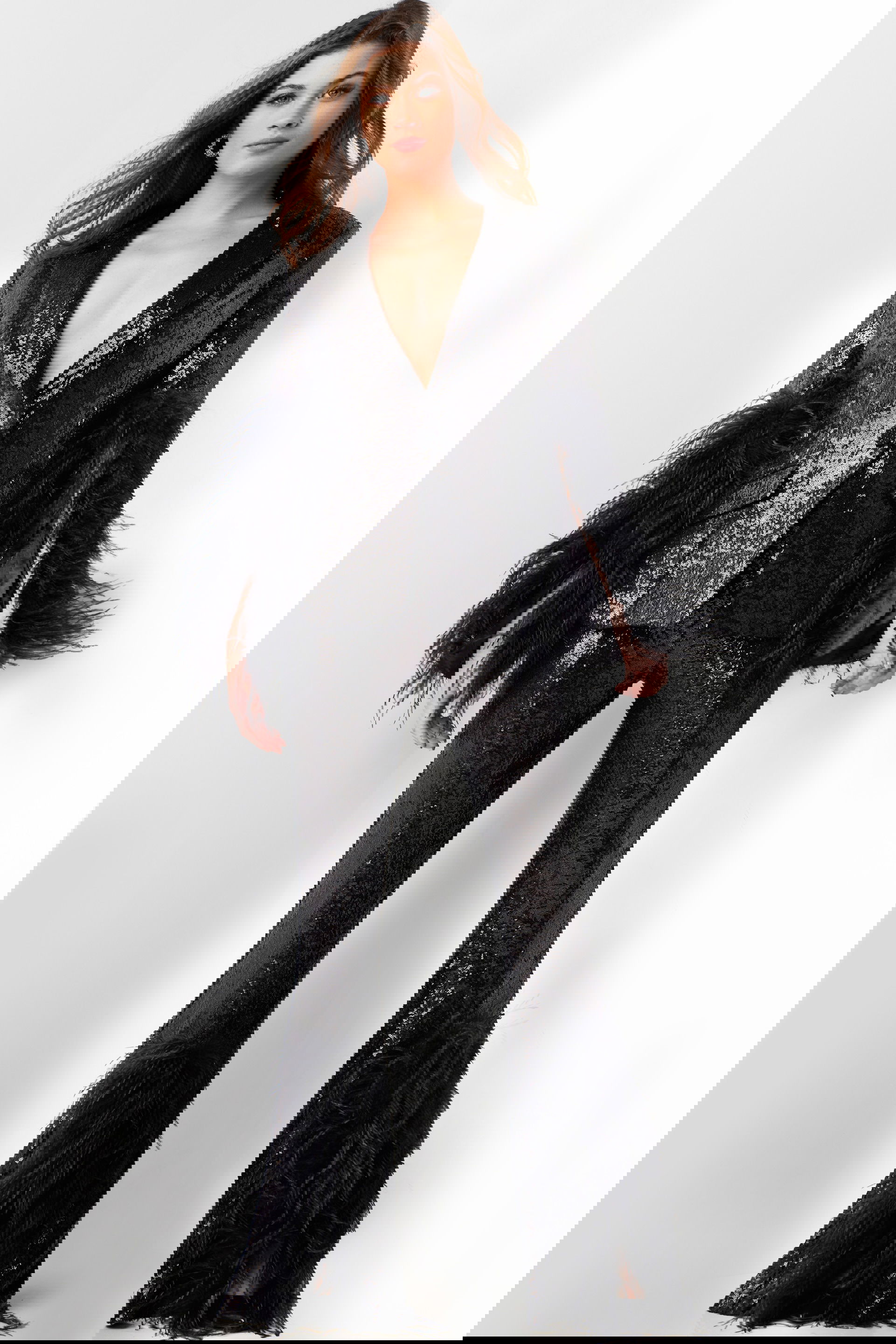 23162-BLACK-50.jpg Model wearing Jovani 23162 black sequin ensemble with feather details