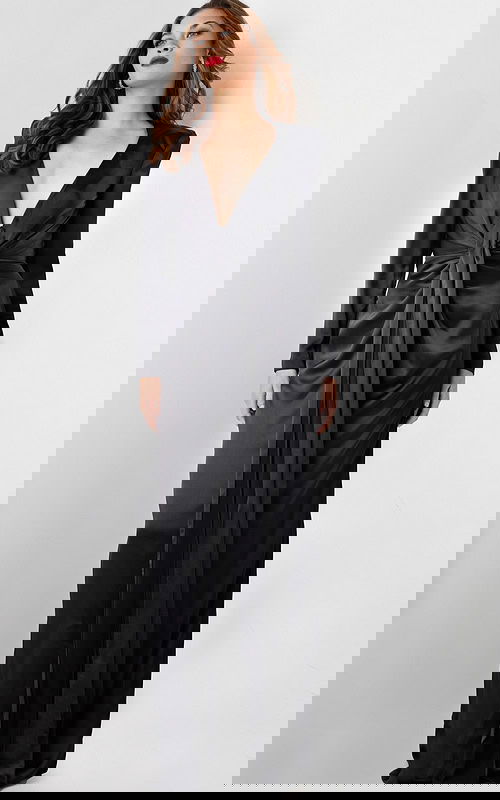 Model wearing Jovani 23180 elegant black gown with deep V-neckline and knot detail, front view.